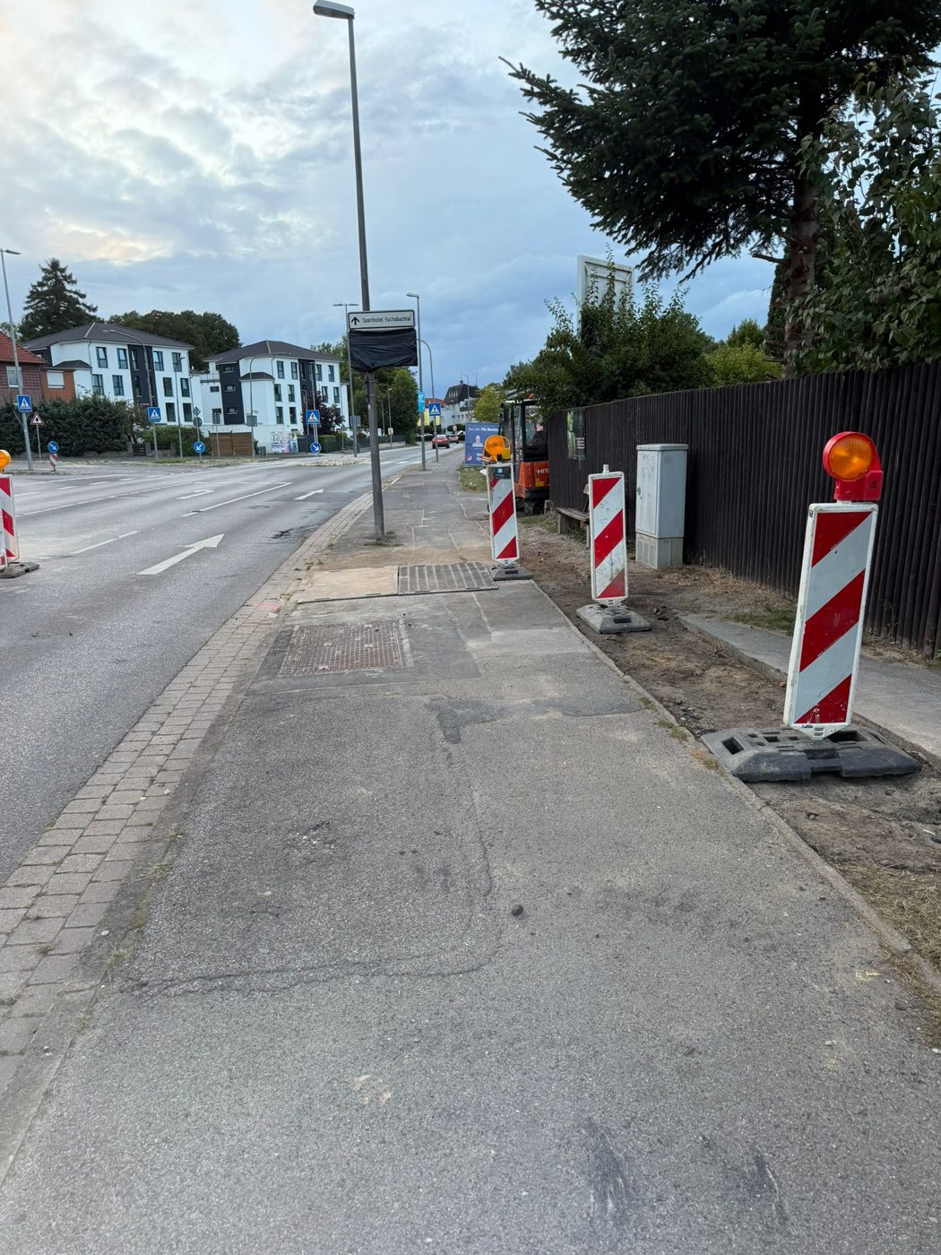 Baustellenbereich mit Absperrbaken entlang eines Gehwegs