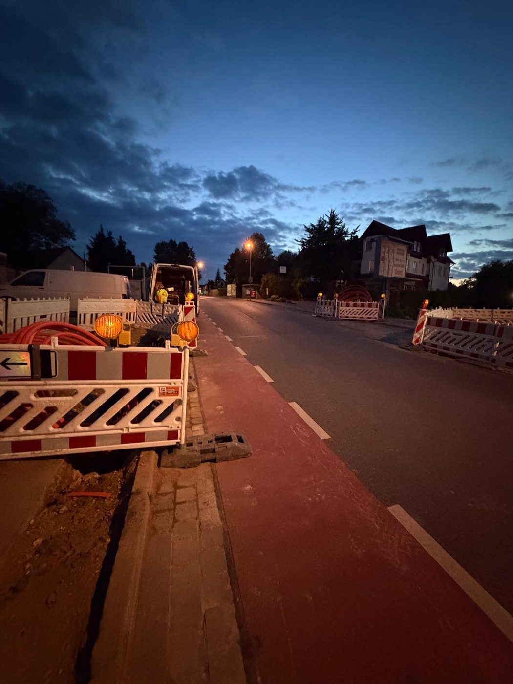 Abgesperrte Baustelle mit Warnleuchten an einer Straße bei Nacht